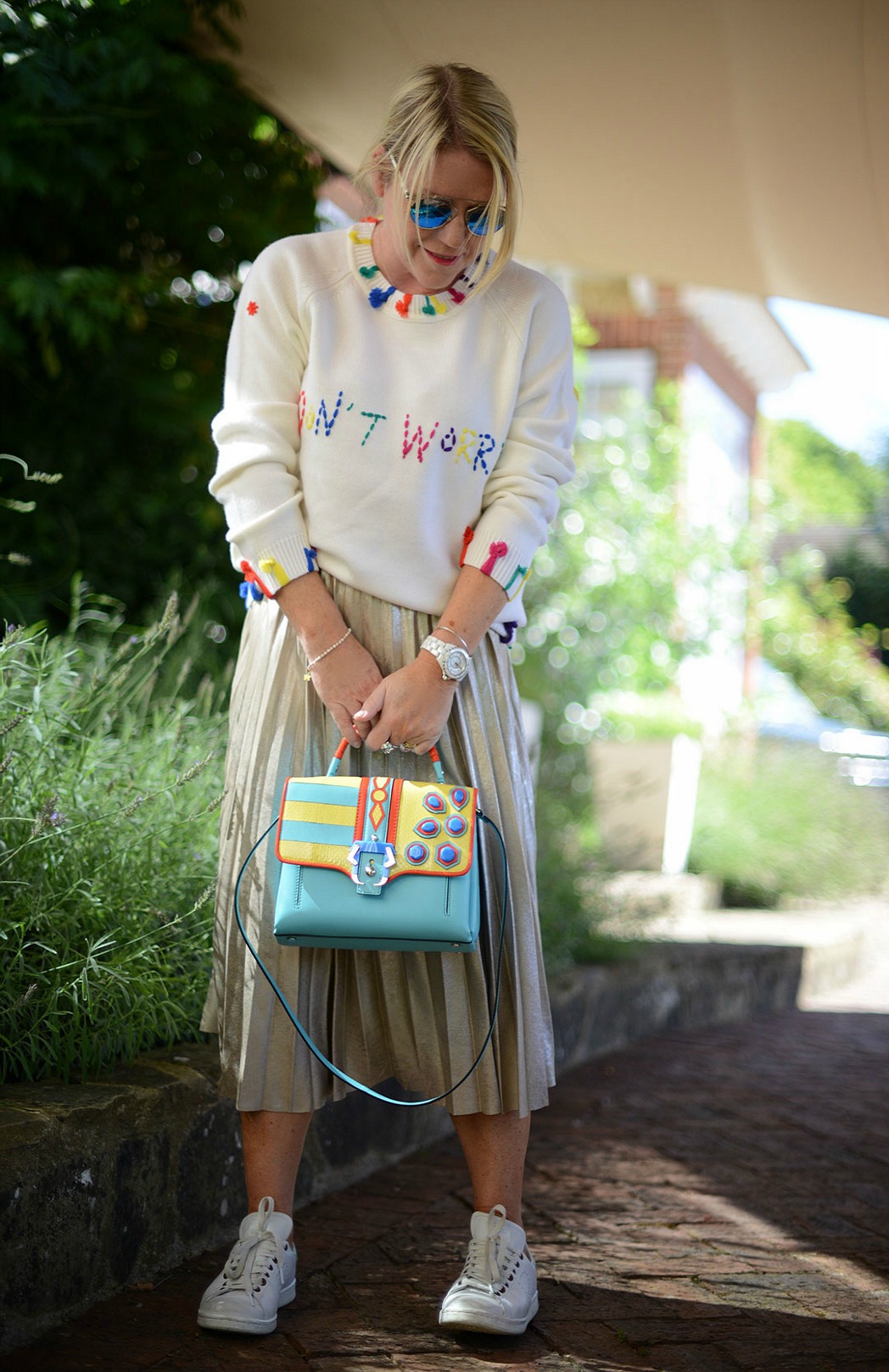 pleated skirt from zara and statement knit by mira mikati worn by stylist and blogger sara delaney